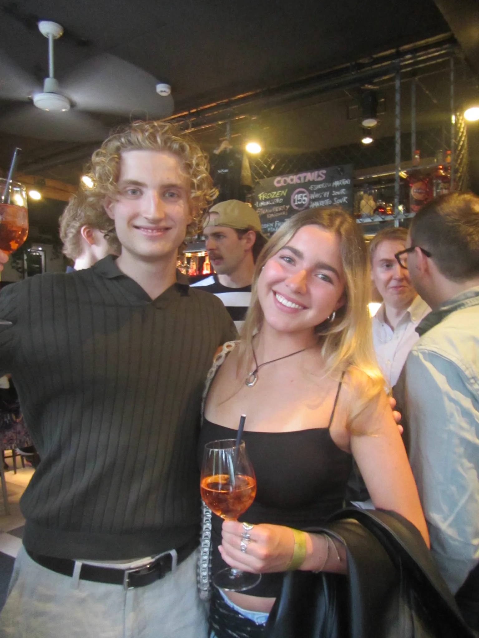Two guests smiling together over cocktails