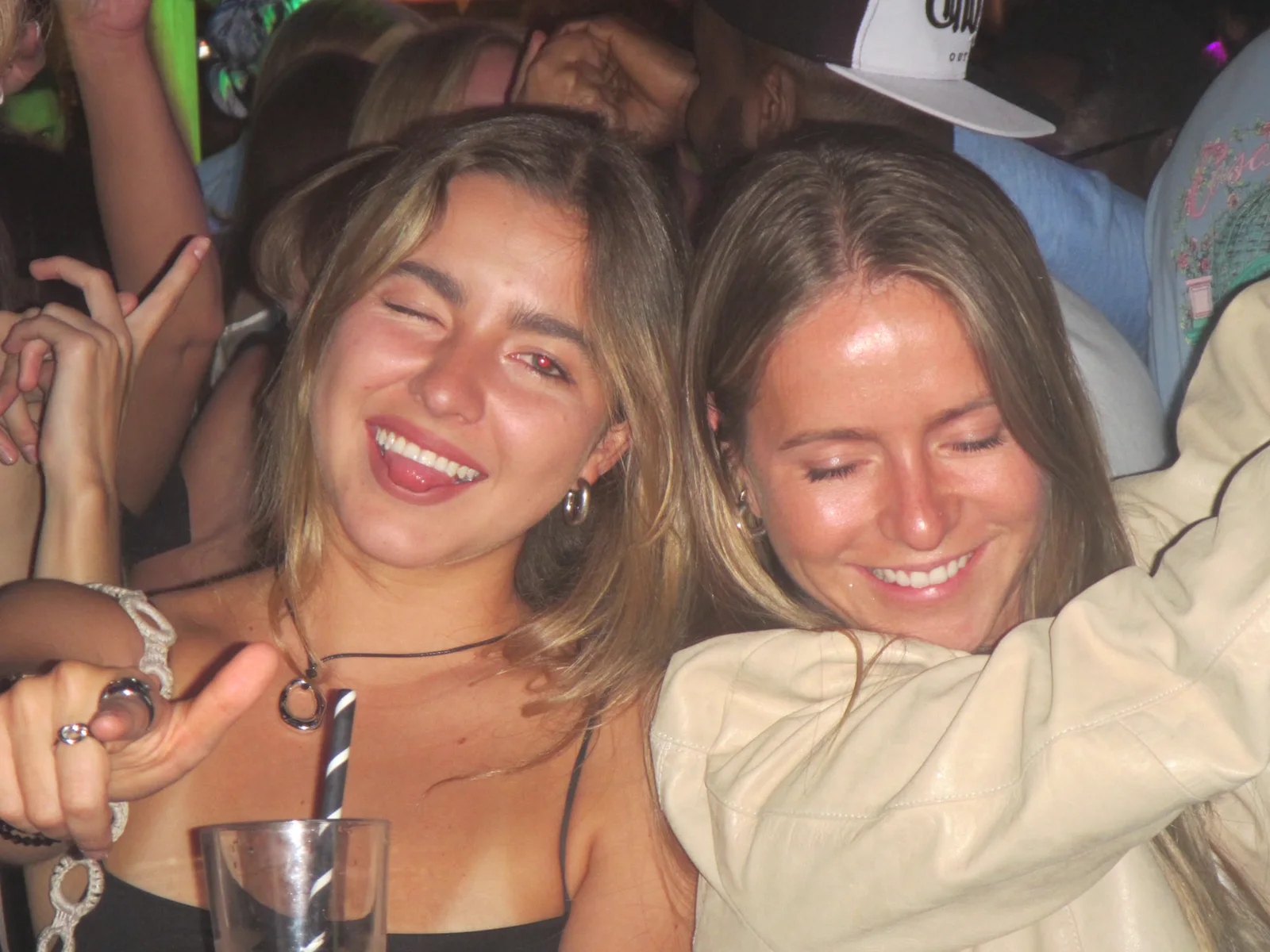 Two friends laughing together in the middle of the crowd