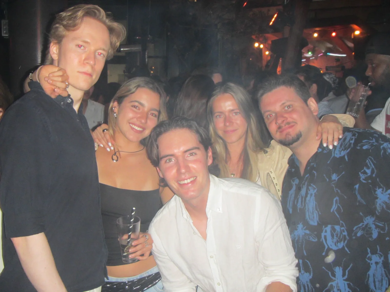 Five guests posing together late in the evening