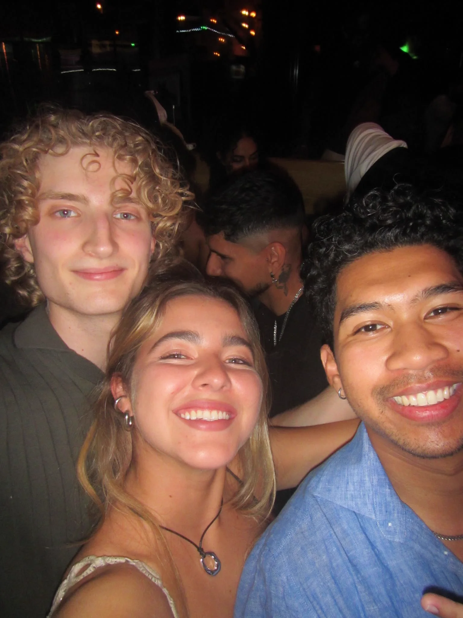 Three friends smiling for a close-up on the dance floor
